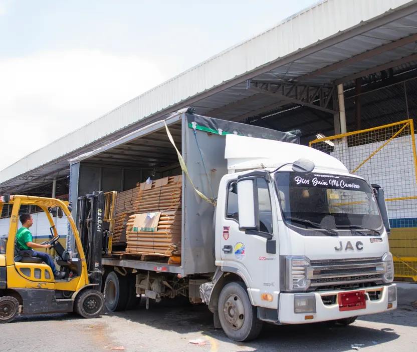 Despacho real de carga: montacargas cargando un furgón de la flota en bodega de cliente